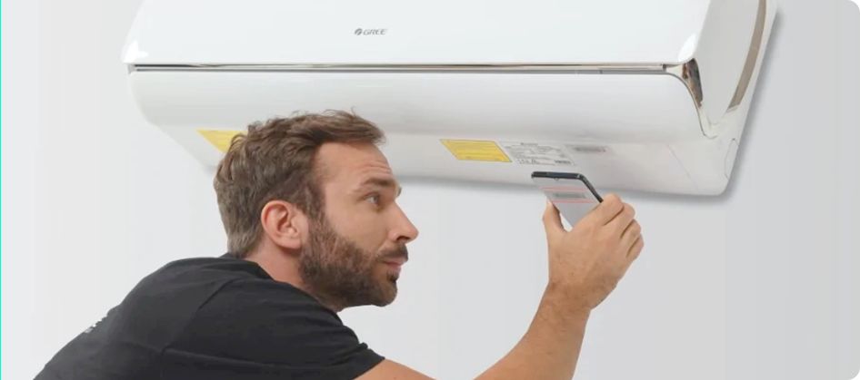 Mężczyzna trzymający telefon i rozmawiający ze swoim dostawcą usług o opcjach klimatyzacji.